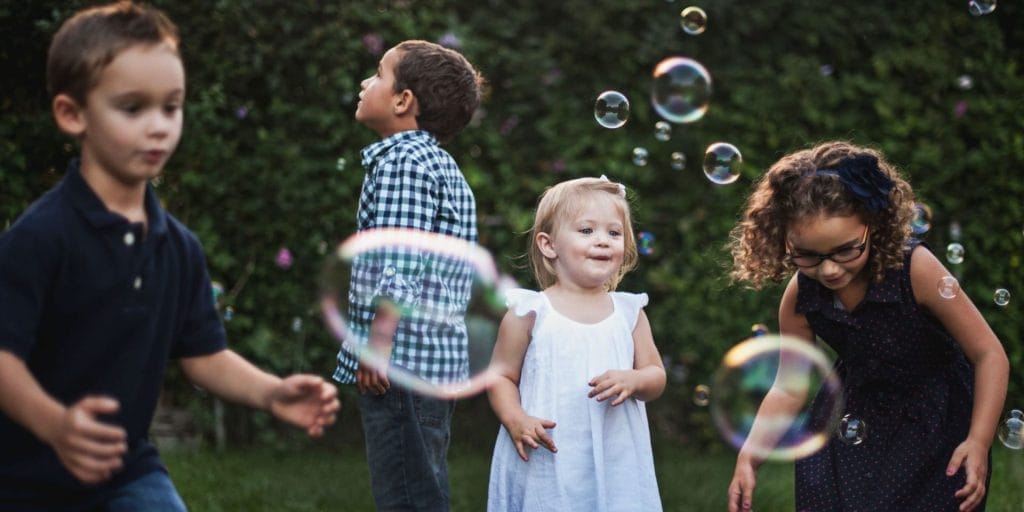 kids in a backyard playing with bubbles in the middle of a cps custody battle